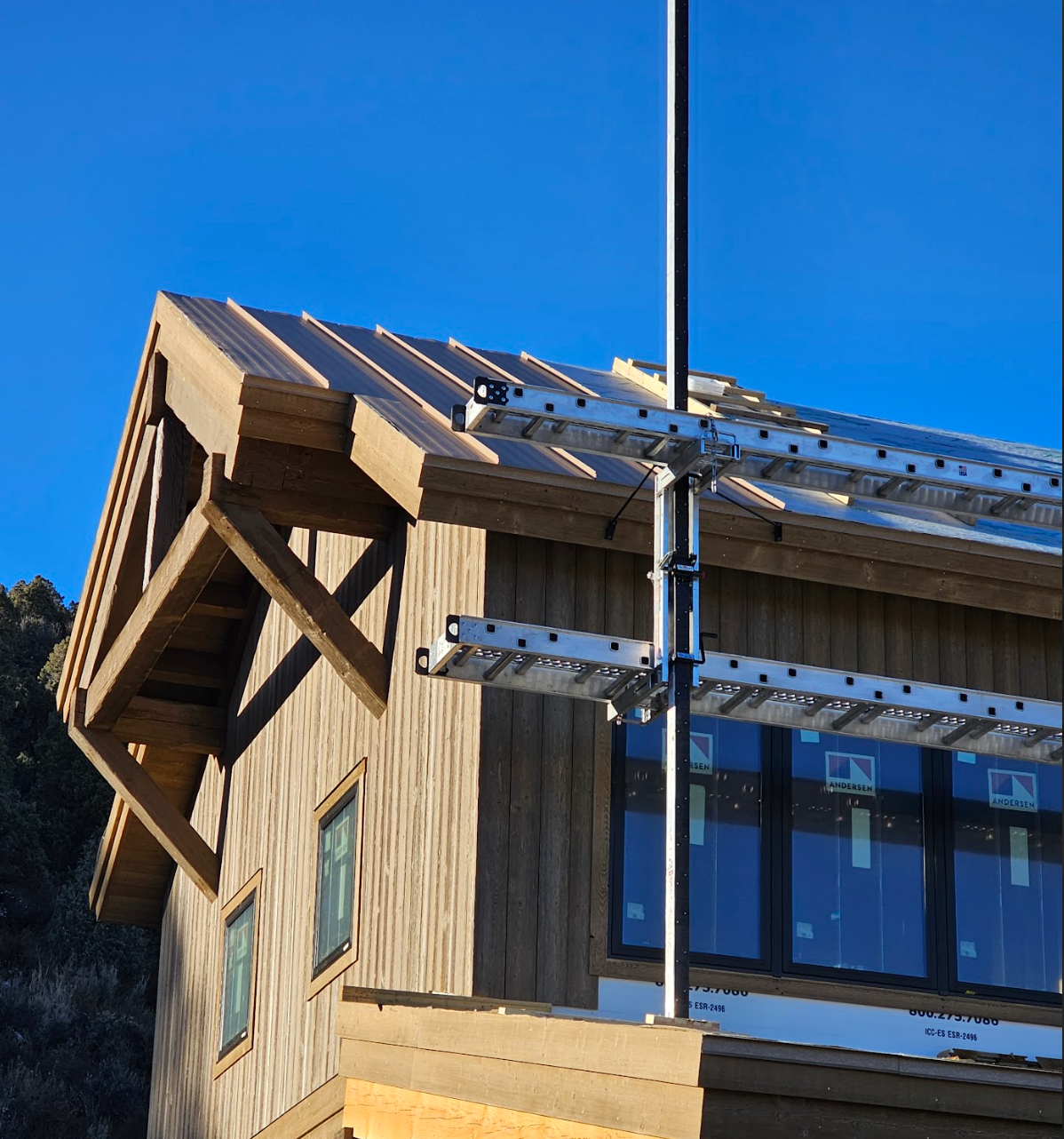 kk Wood-sided house under construction with new standing-seam metal roof and scaffolding.