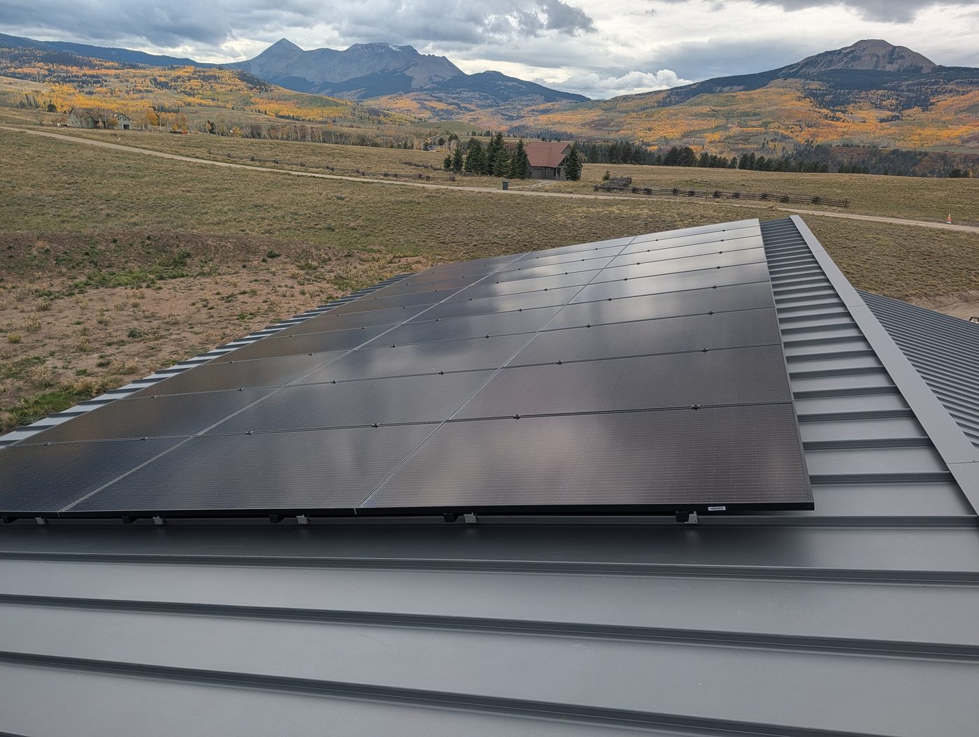 Gray Zinc Matte standing seam metal roof beside rooftop solar panels near Telluride